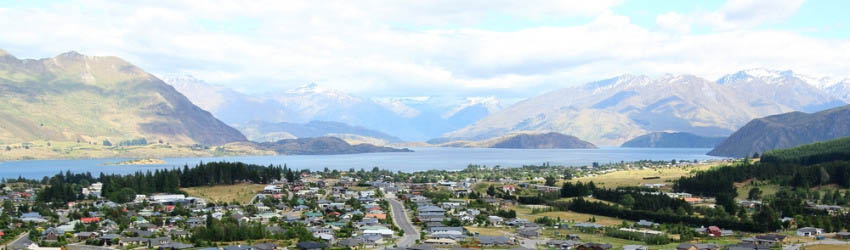 panoramic view of properties near mountains and lake